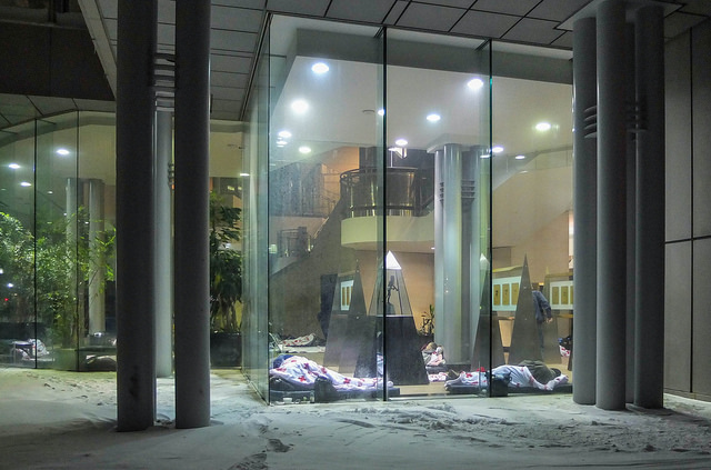 In extreme cold, Metro Hall becomes a warming centre for the homeless, who sleep at night under Red Cross blankets next to the glass wall