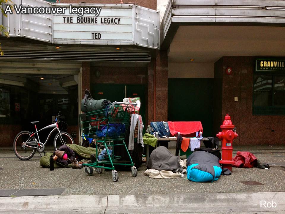 A group sleeping in front of a theatre with all their belongings