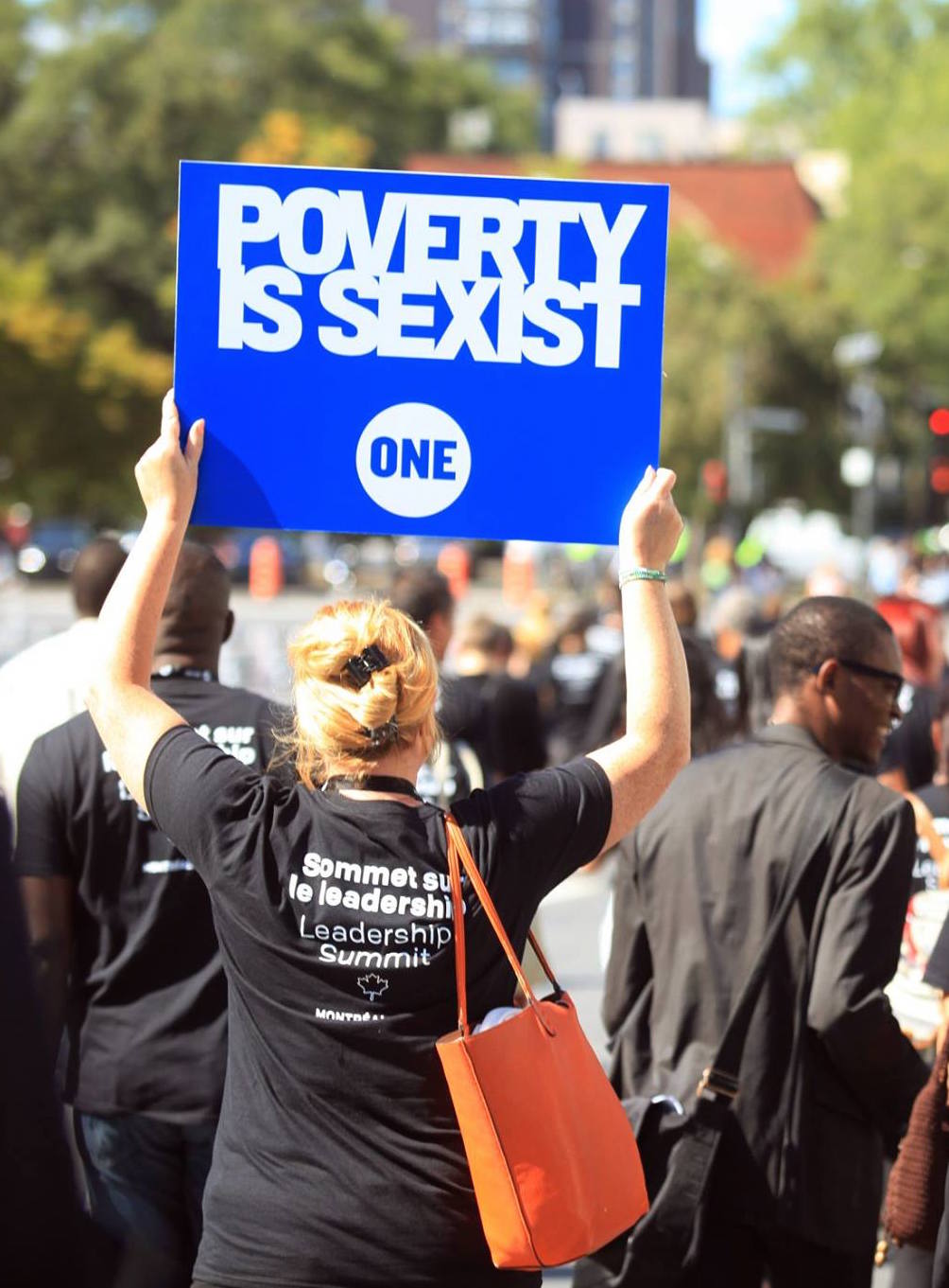 A woman with a sign, "Poverty is sexist."